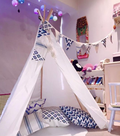 Blue and white teepee with bunting and cushions